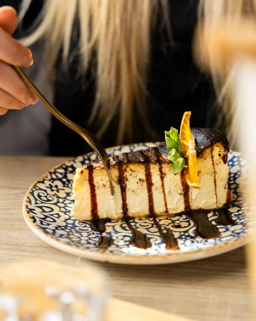 San Sebastian Cheesecake mit Schokoladensauce auf gemustertem Teller